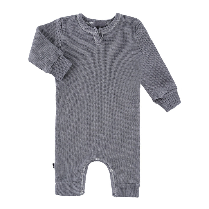 A long-sleeved eco-thermal romper for babies, featuring a splatter print in blue and gray colors with a henley opening and snap closures.