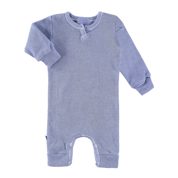 A long-sleeved eco-thermal romper for babies, featuring a splatter print in blue and gray colors with a henley opening and snap closures.