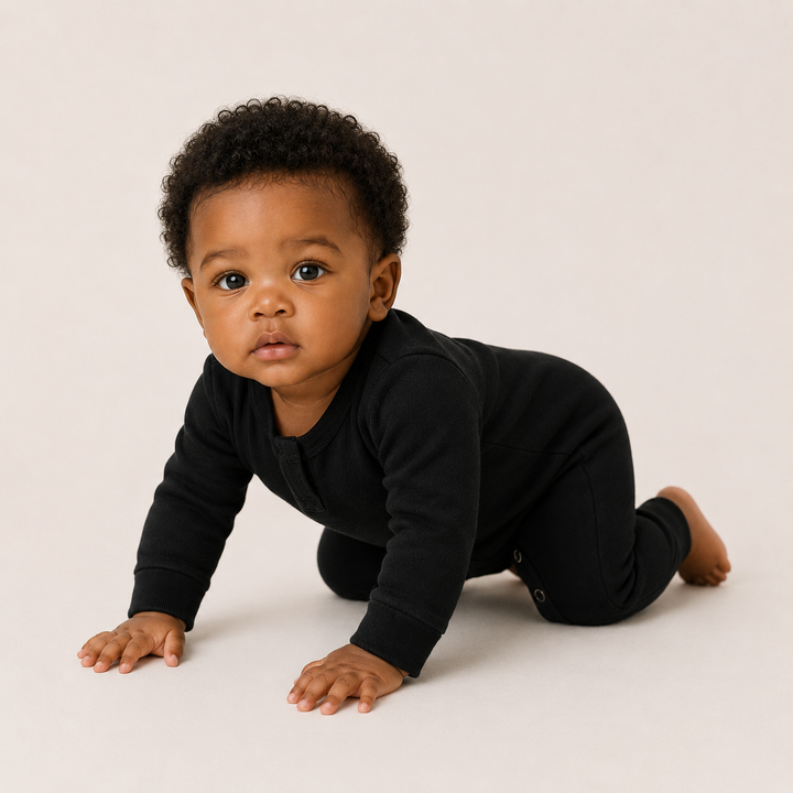 Baby crawling while wearing the PAIGELAUREN Fleece Sweatshirt Henley Romper in Black