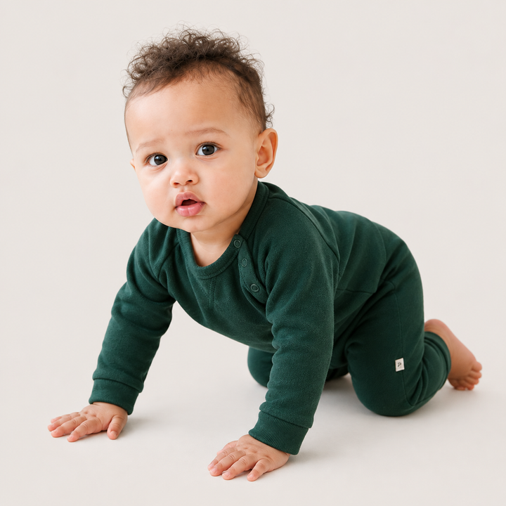 Baby crawling while wearing the PAIGELAUREN Fleece Sweatshirt Raglan Romper in dark green