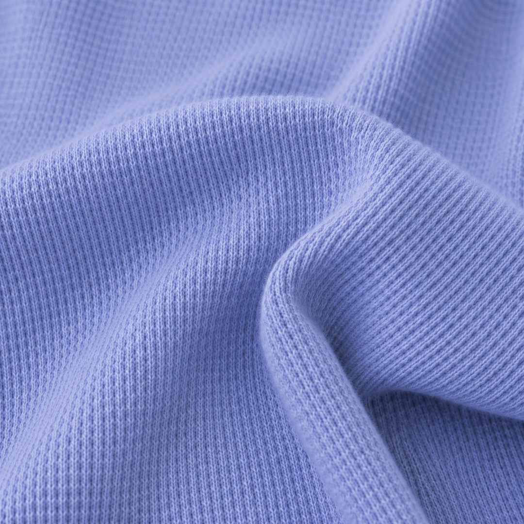 Close-up of soft garment dyed thermal knit fabric in blue showing premium texture