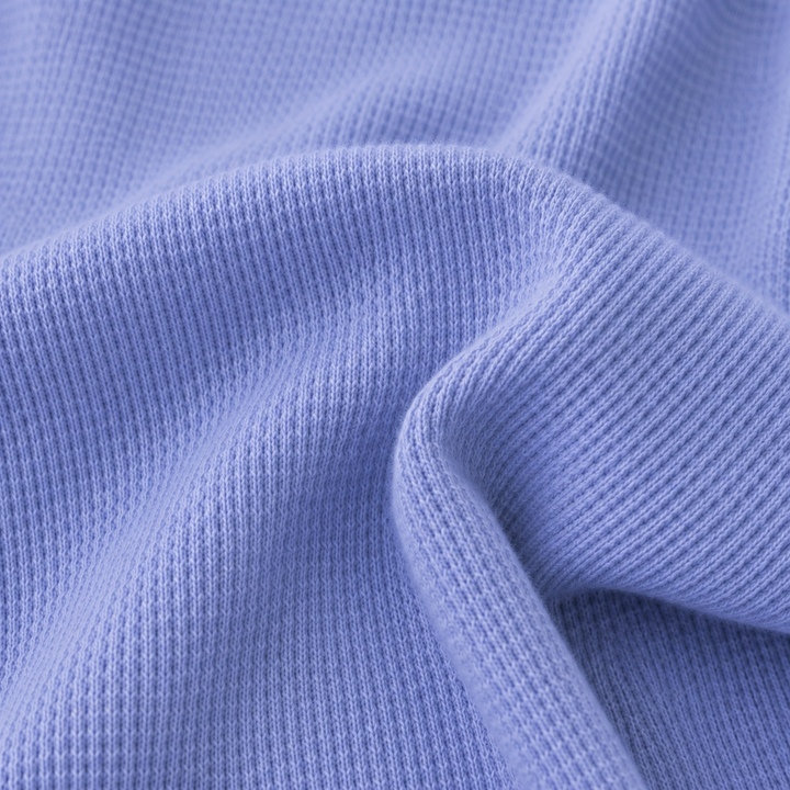 Close-up of soft garment dyed thermal knit fabric in blue showing premium texture