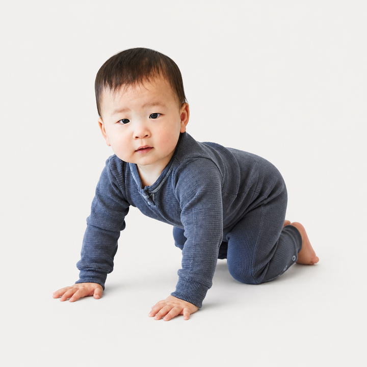 Baby crawling in the PAIGELAUREN Garment Dyed Thermal Romper in soft blue thermal knit. Gray