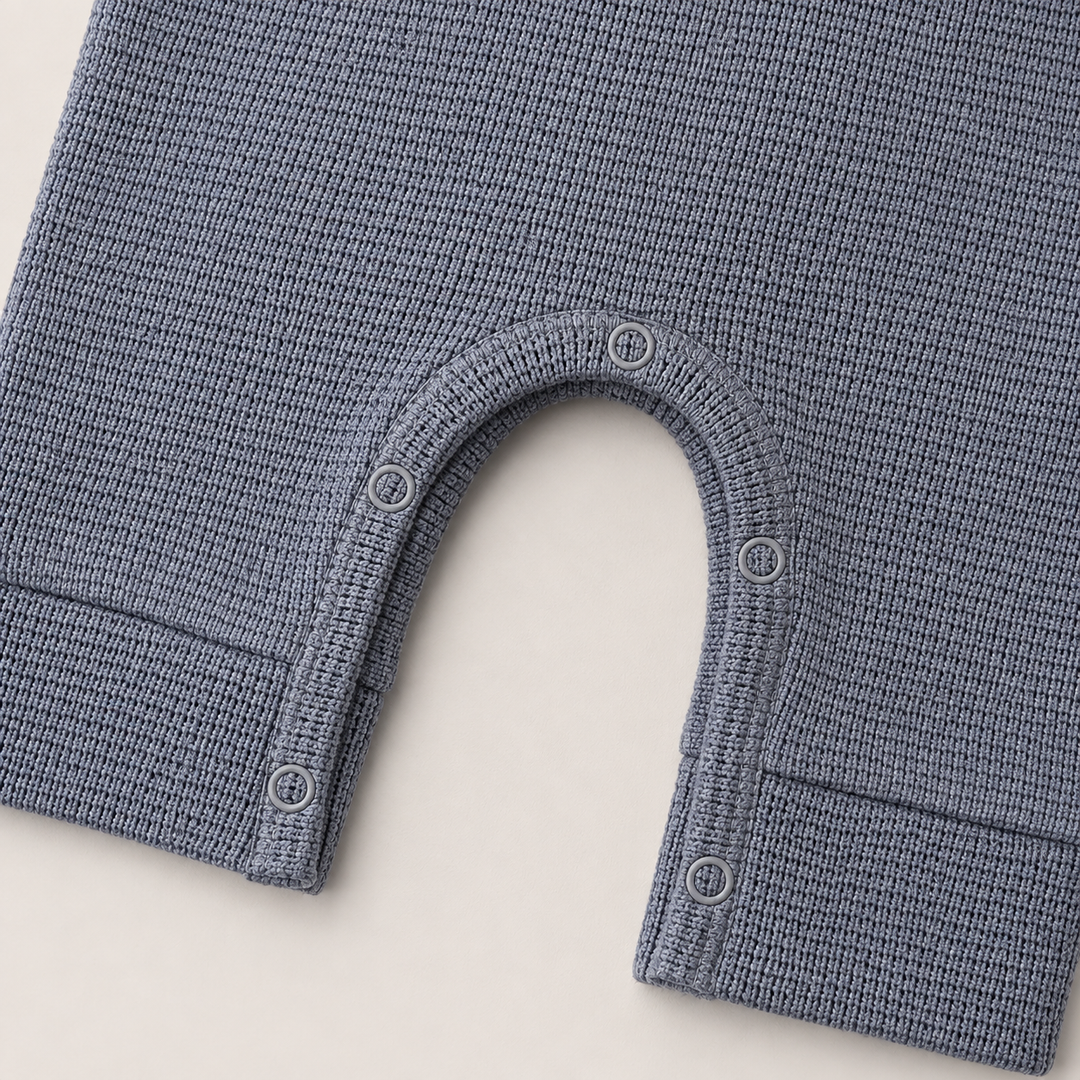 Close-up of matching snap closure and thermal knit on the PAIGELAUREN Garment Dyed Thermal Romper. Gray