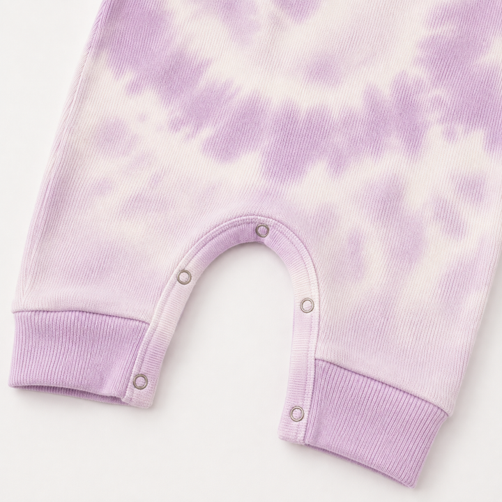Close-up of the color-matched ring snap inseam and reinforced stitching on the PAIGELAUREN Lavender Baby Rib Tie Dye Tank Overall