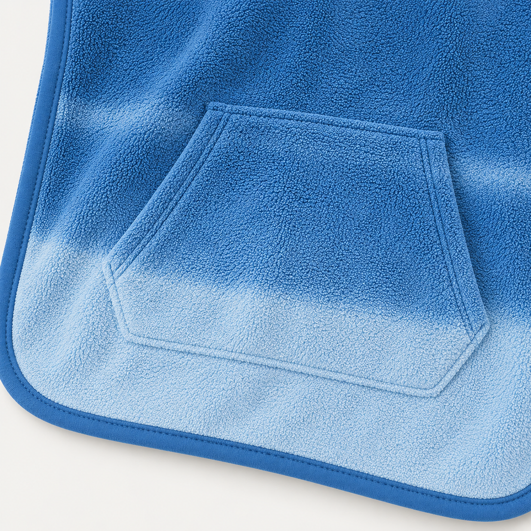 Close-up of blue ombré terry poncho kangaroo pocket with stitching and soft textured fabric
