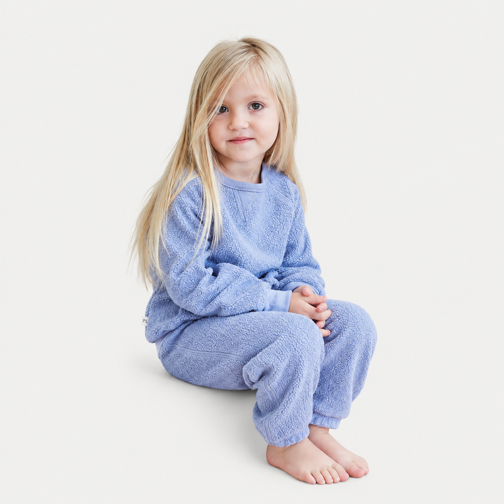 Child in PAIGELAUREN Blue Sherpa matching sweatshirt and sweatpant set