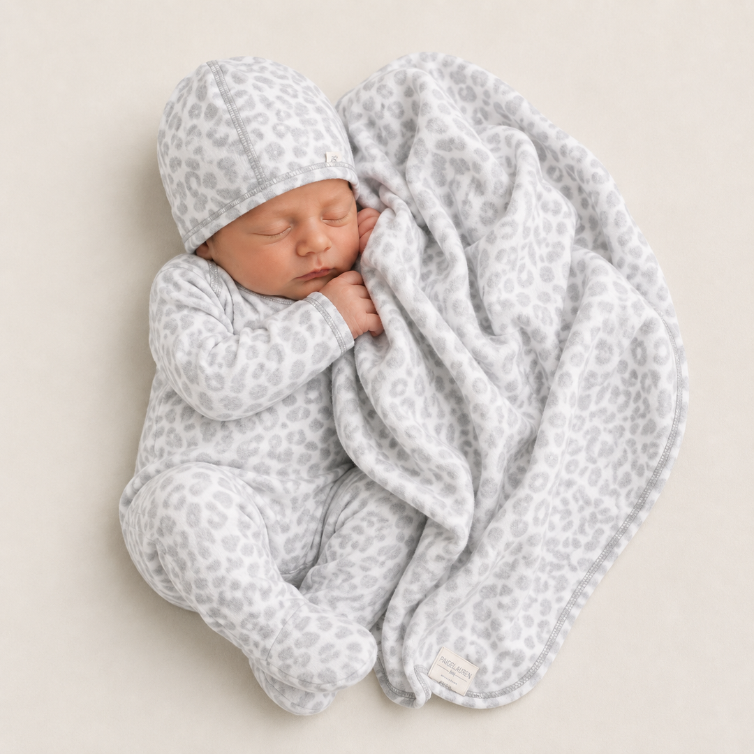 Newborn wearing PAIGELAUREN Gray and White Brushed Hacci Animal Romper and beanie while snuggling with the matching blanket