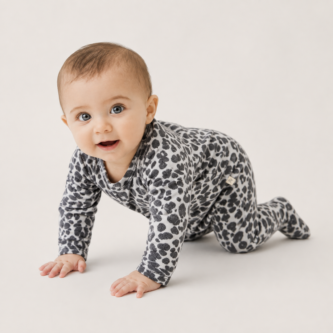 Baby crawling in PAIGELAUREN black and white animal print Brushed Hacci Footed Pajama