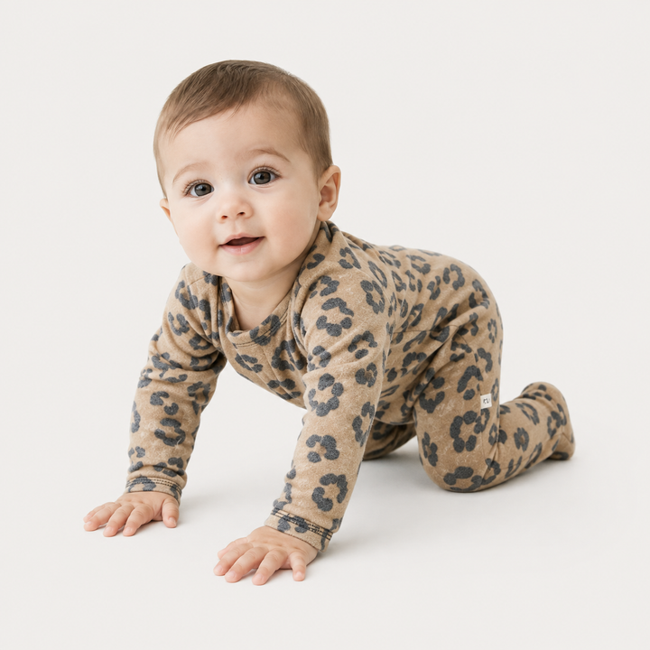 Baby crawling in the PAIGELAUREN camel animal print Brushed Hacci Footed Pajama