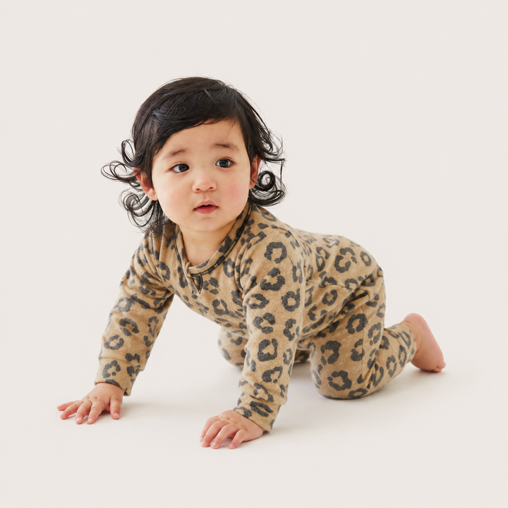 Baby crawling in the PAIGELAUREN Brushed Hacci Animal Henley Romper. Black/Taupe