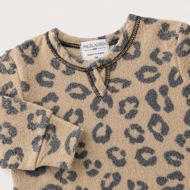 Henley neckline detail on the PAIGELAUREN Brushed Hacci Animal Henley Romper. Black/Taupe