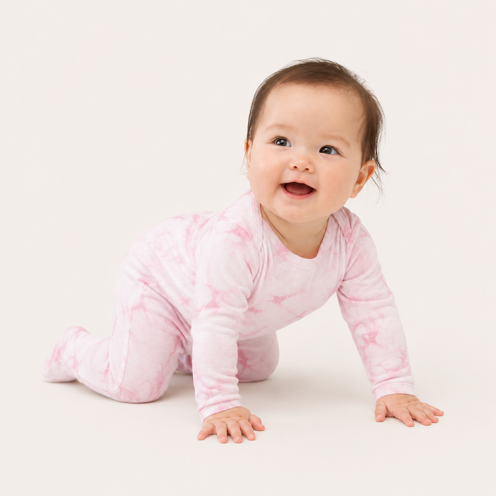 Baby crawling in PAIGELAUREN Pink Crystal Rib Footie Pajama