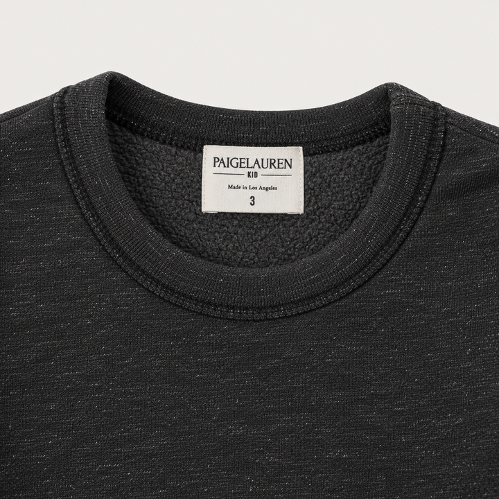 Close-up of PAIGELAUREN Heathered Black fleece sweatshirt neckline, label and soft fleece interior