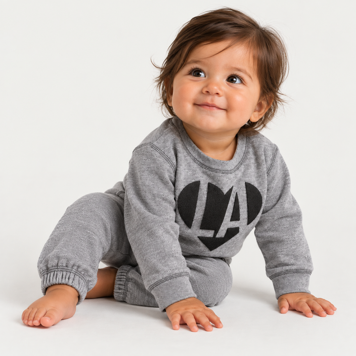 Baby wearing Heathered Gray PAIGELAUREN Fleece Sweat Set with black puffed LA heart graphic