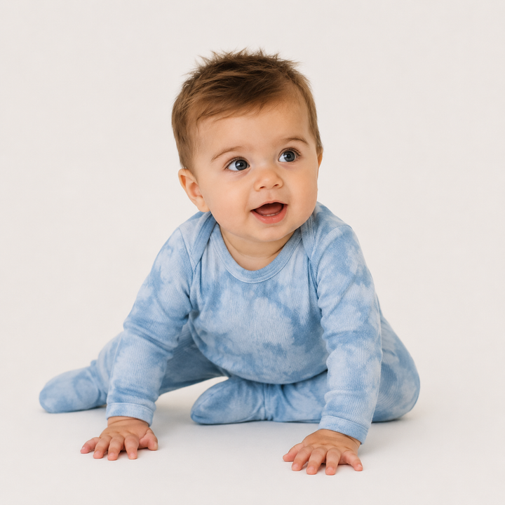 Baby sitting in PAIGELAUREN blue Marble Brushed Hacci Footed Pajama