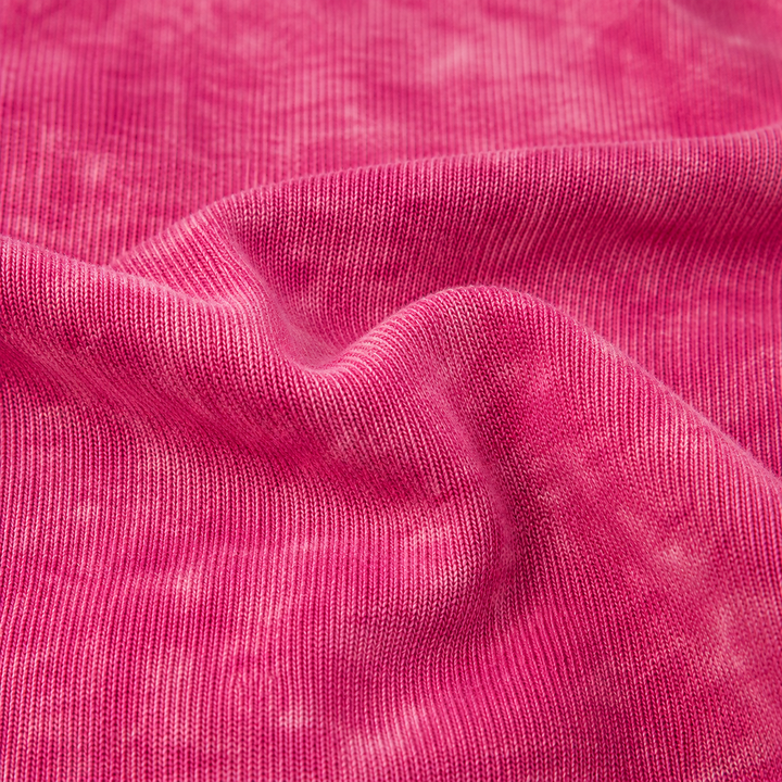 Close-up of soft baby rib fabric with mineral wash texture in Magenta