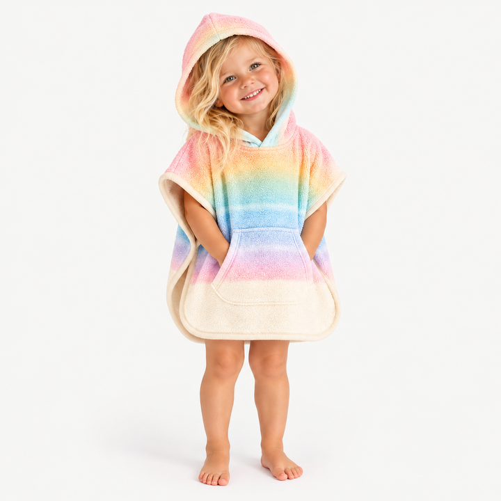 Blonde toddler smiling with hood up in pastel rainbow loop terry poncho