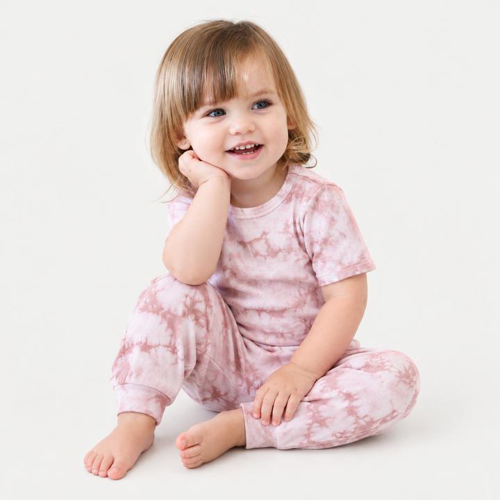 Toddler seated in PAIGELAUREN Pink Crystal Rib Tee + Legging Set