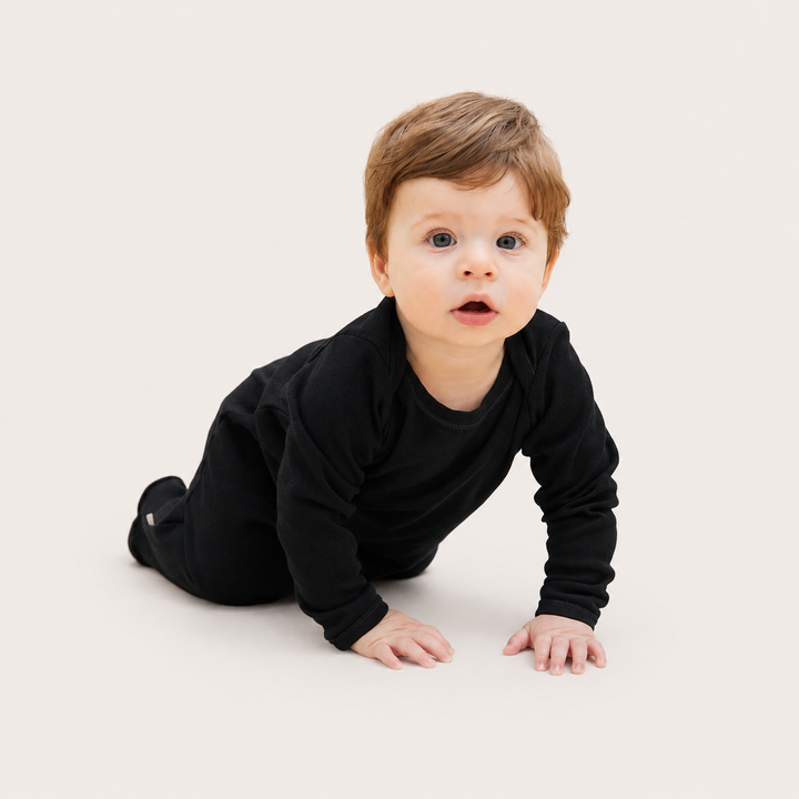 Baby crawling in PAIGELAUREN Black Rib Lap Tee Footie Pajama