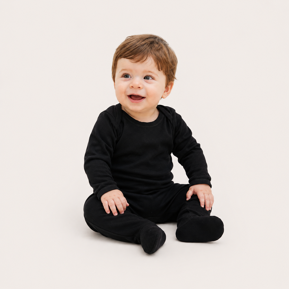 Baby sitting in PAIGELAUREN Rib Lap Tee Footie Pajama in Black