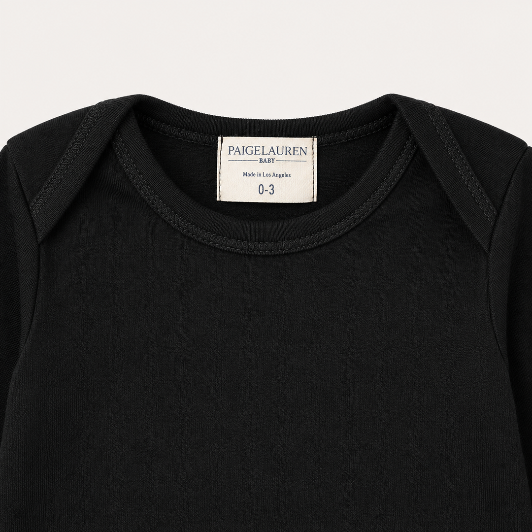 Lap shoulder neckline and PAIGELAUREN label detail on Black Rib Footie Pajama