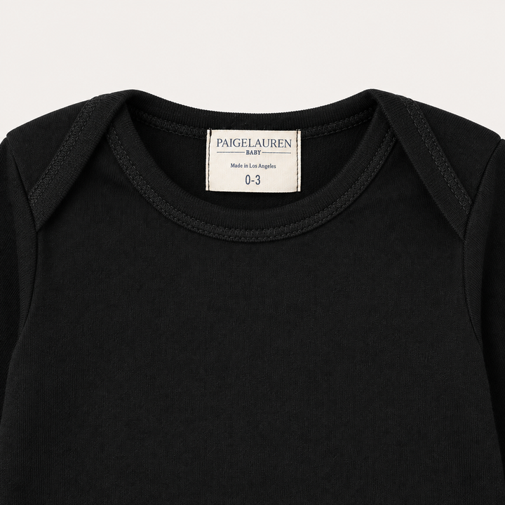 Lap shoulder neckline and PAIGELAUREN label detail on Black Rib Footie Pajama