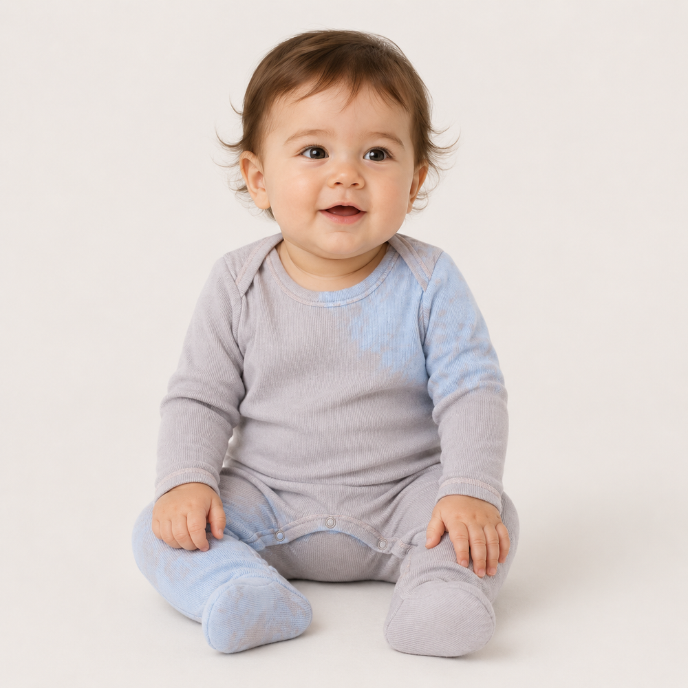 Baby sitting in PAIGELAUREN pink and blue Rib Tie Dye Footed Pajama