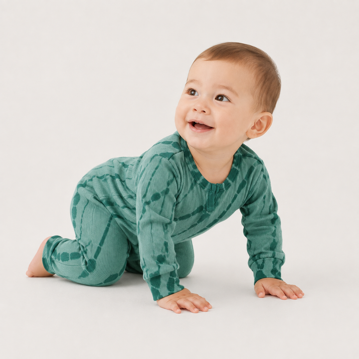 Crawling baby wearing the PAIGELAUREN Ribbed Green Tonal Tie Dye Henley Romper.