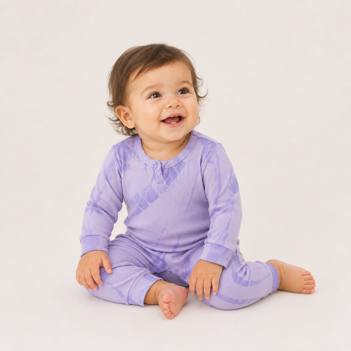 Baby wearing the PAIGELAUREN Ribbed Lavender Tonal Tie Dye Henley Romper.