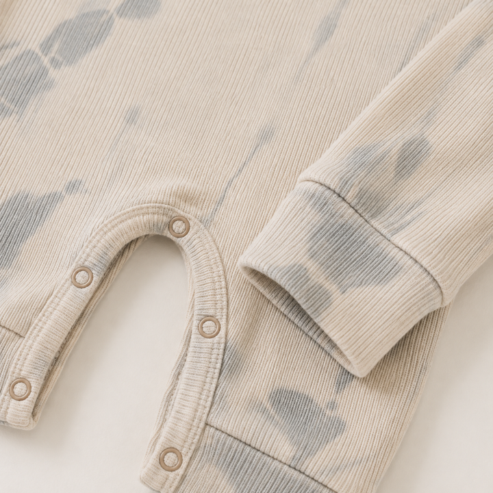 Ribbed sleeve cuff and tonal tie dye detail on the PAIGELAUREN baby romper. Oat