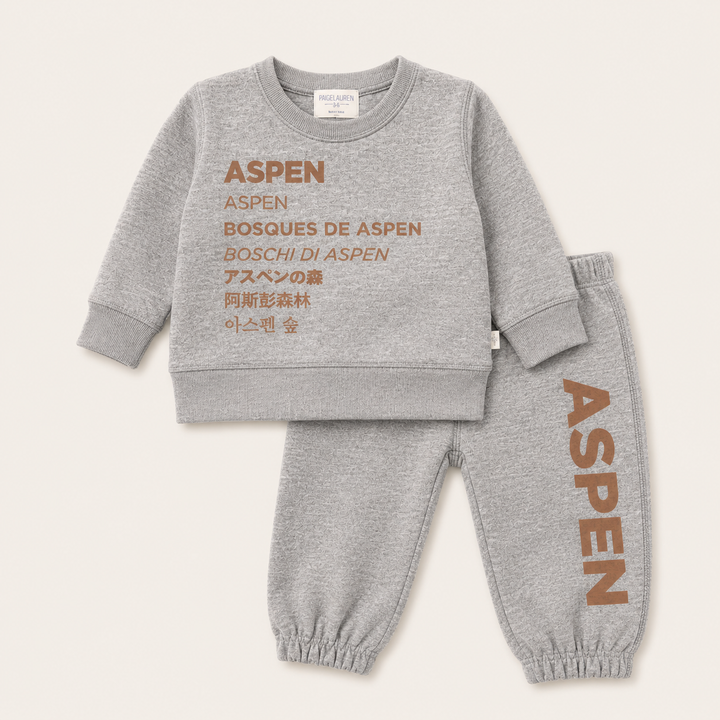 A two-piece kids' loungewear set by Aspen in heather gray, featuring a sweatshirt and jogger pants with brown text graphics. The sweatshirt features 'ASPEN BOSQUES DE ASPEN BOSCHI DI ASPEN' along with Japanese and Korean text.