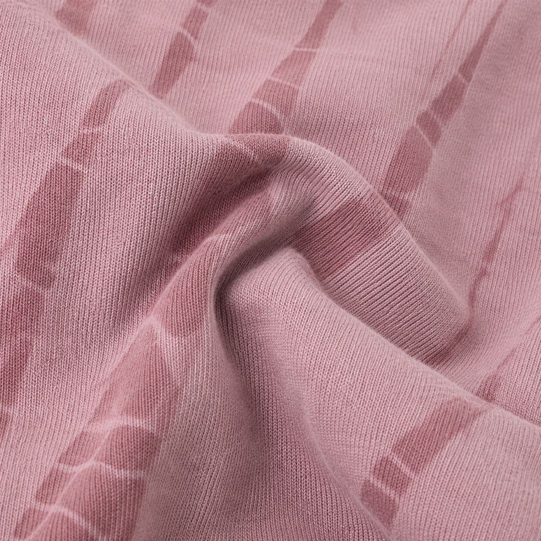 A close-up of draped dusty pink fabric with a subtle tonal striped pattern.