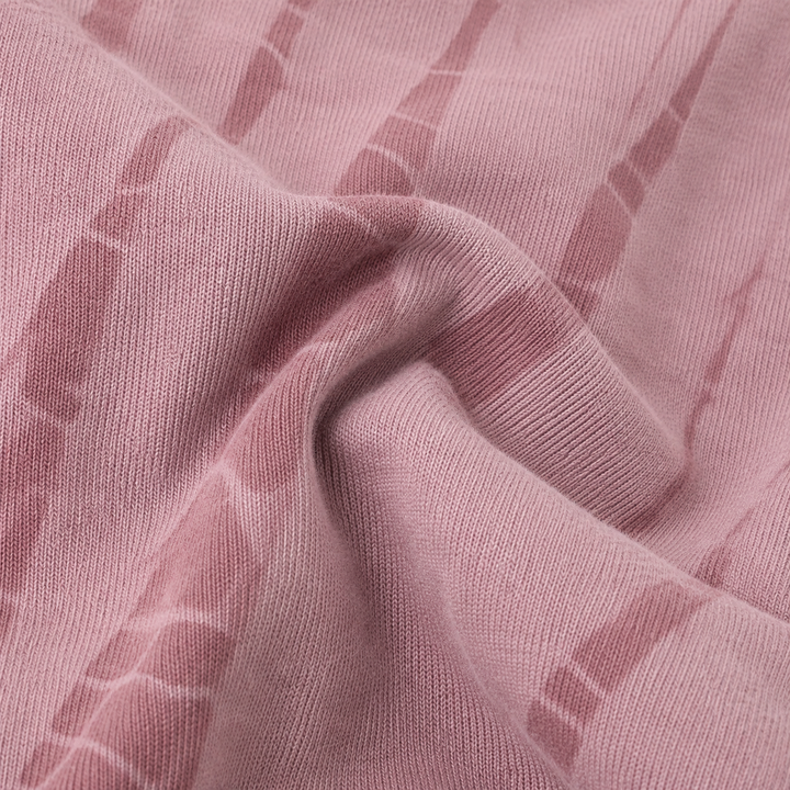 A close-up of draped dusty pink fabric with a subtle tonal striped pattern.