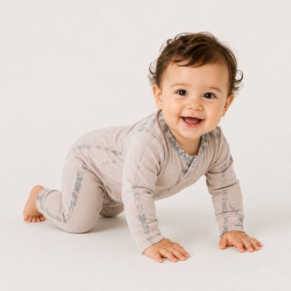 Crawling baby wearing the PAIGELAUREN beige tonal-dyed fleece romper.
