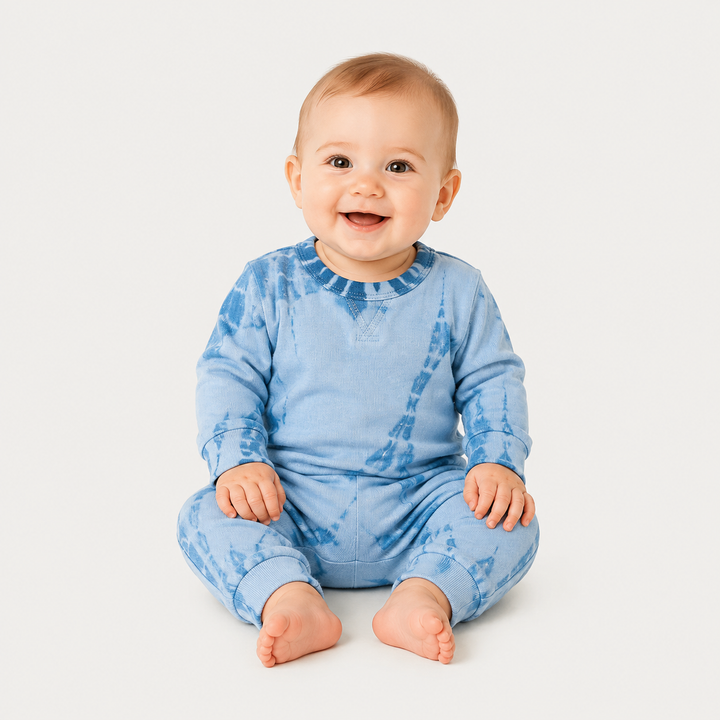 Baby wearing the PAIGELAUREN Blue tonal dyed romper in a minimalist studio.