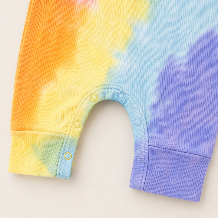 Close-up of the color-matched ring snap closure and reinforced inseam on the PAIGELAUREN Pink Rainbow Ribbed Tank Overall