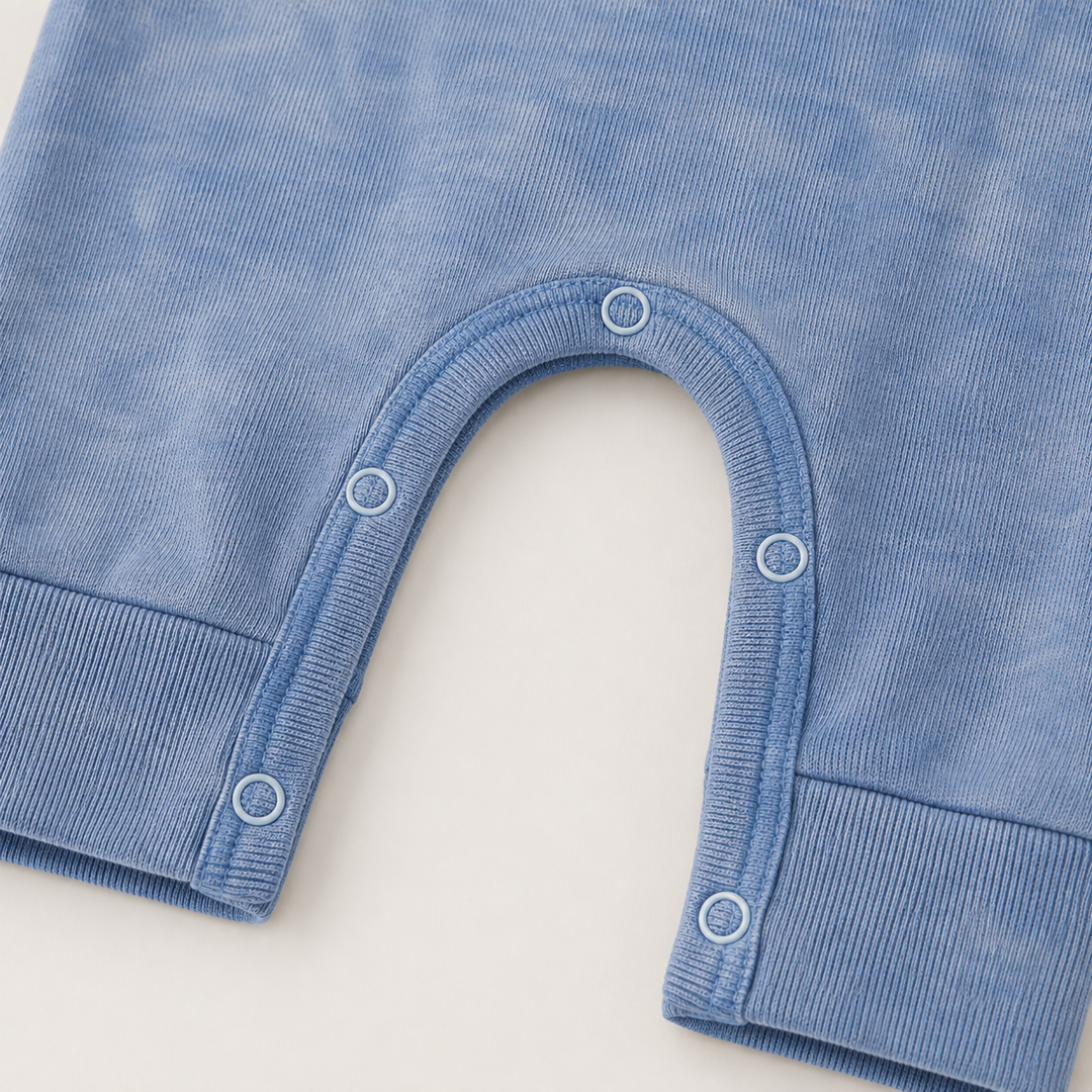 Close-up of matching snap closures and rib knit detail on the PAIGELAUREN Rib Marble Henley Romper. Blue Marble