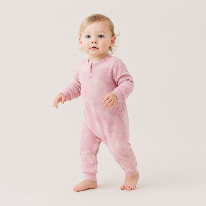 Toddler wearing the PAIGELAUREN Rib Marble Henley Romper in soft pink marble wash