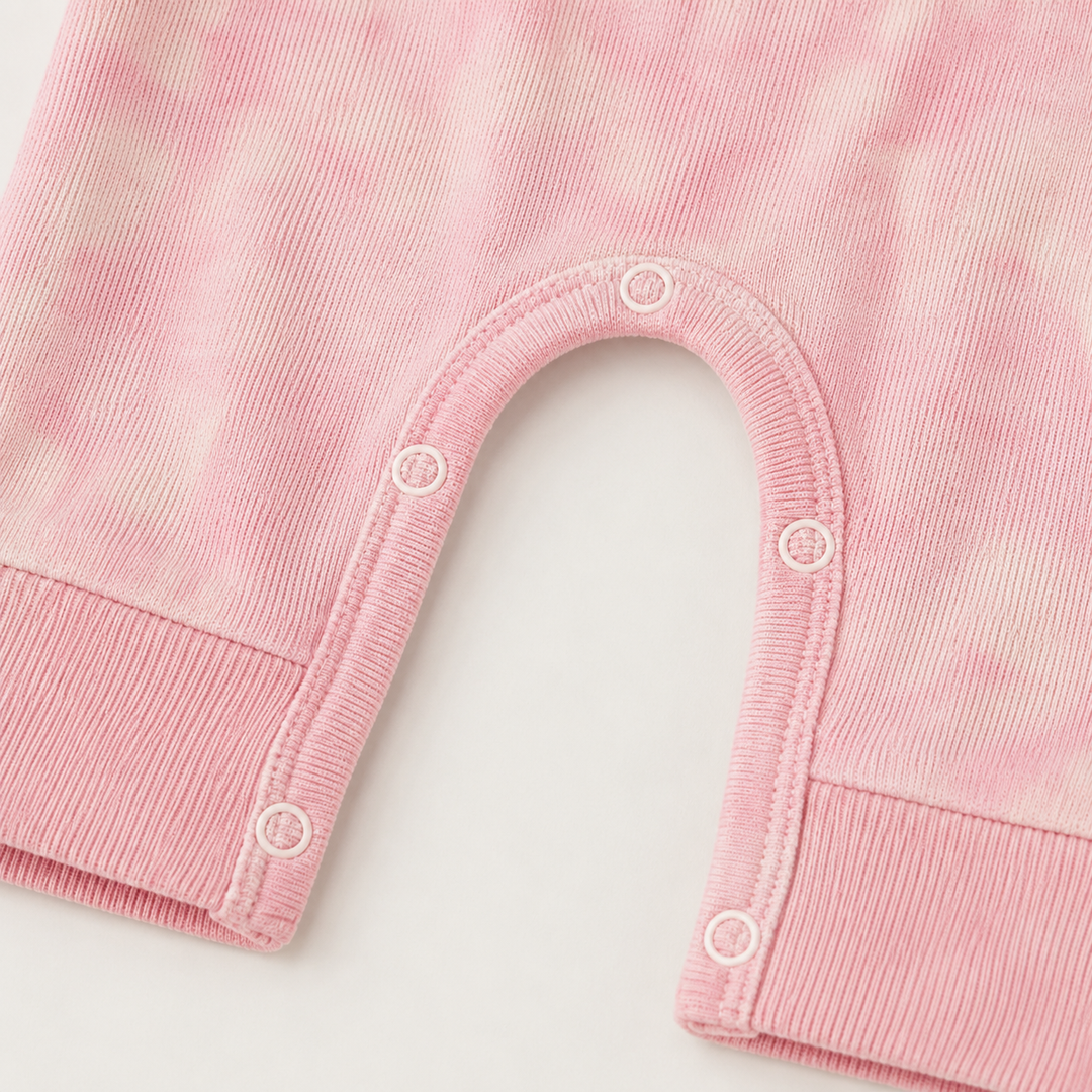 Close-up of matching snap closures and rib knit detail on the PAIGELAUREN Rib Pink Marble Henley Romper