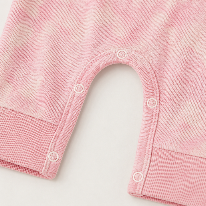 Close-up of matching snap closures and rib knit detail on the PAIGELAUREN Rib Pink Marble Henley Romper