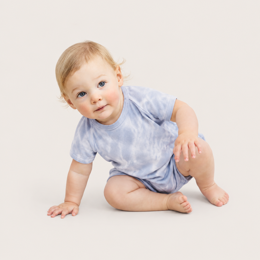 Baby sitting while wearing the PAIGELAUREN Light Blue Marble Rib Shortall Onesie
